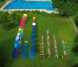 Rows of towels, umbrellas, people, toys in OCD order by size and color